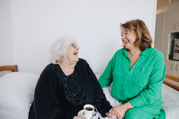 09 03 2023 Zorgpartners De Breeje Hendrick Bewoner Medewerker Lachen Kamer Koffie Zitten Bed Lachen Vasthouden