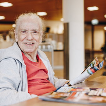 09 03 2023 Zorgpartners De Breeje Hendrick Bewoner Tafel Lezen Tijdschrijft Lachen