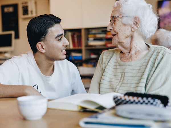 Ronssehof Bewoner Client Jongere Jongen Lachen Interactie Boek Kopje Tafel Stagiair