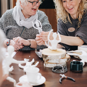 09 03 2023 Zorgpartners De Breeje Hendrick Bewoner Medewerker Welzijn Handwerken Activiteit Close Up Staand Lachen