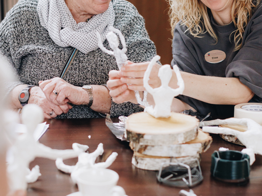 09 03 2023 Zorgpartners De Breeje Hendrick Bewoner Medewerker Welzijn Handwerken Activiteit Close Up Staand Lachen